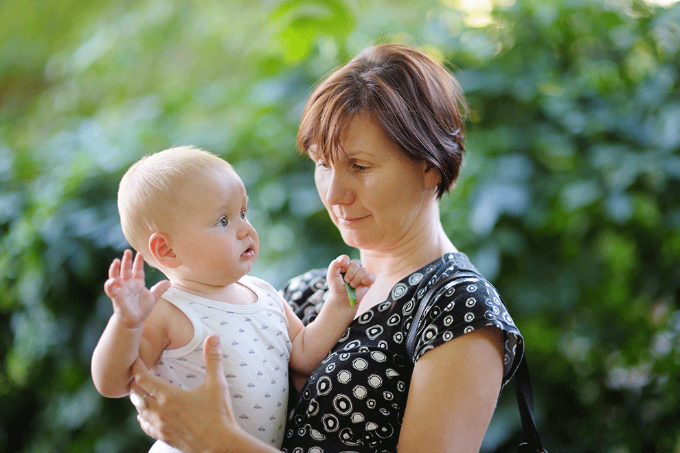 assistante maternelle portant un enfant dans les bras
